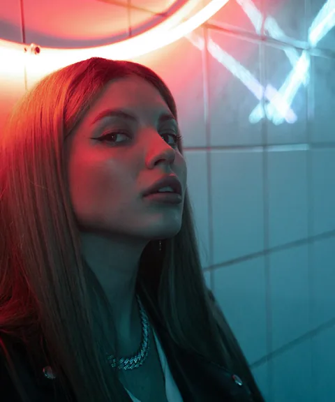 An editorial portrait illuminated by saturated neon light